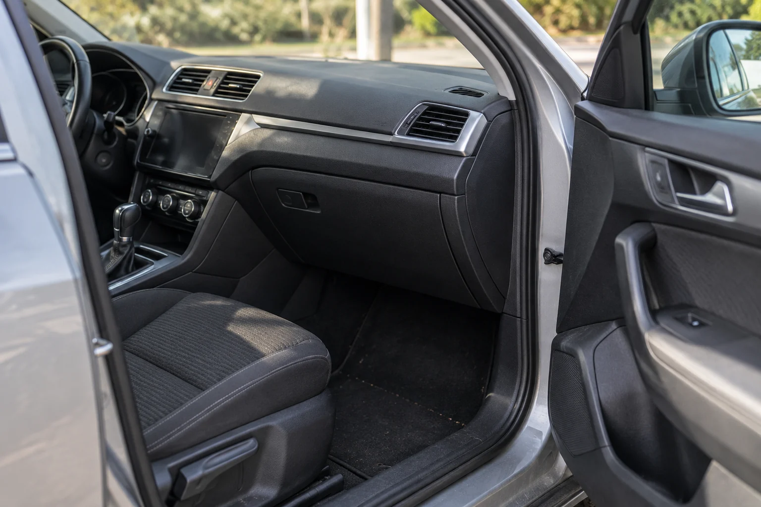 Pro atviras keleivio dureles matomas automobilio salonas ir uždaryta daiktadėžė.